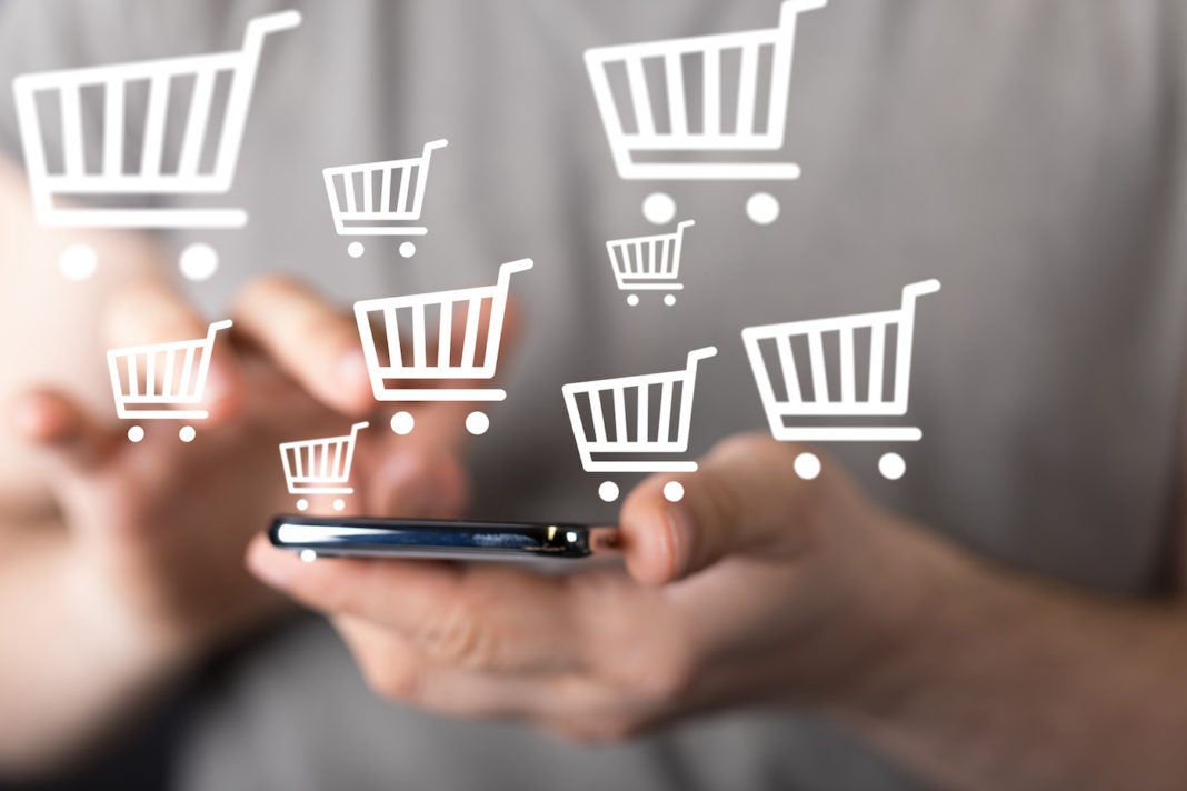 Person using smartphone with icons of shoping cart superimposed over the image.